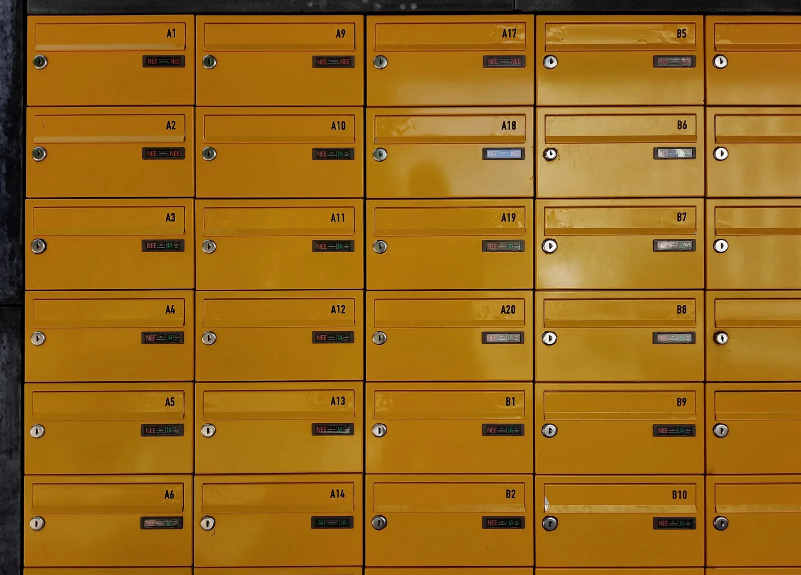 A wall of numbered brass post-office mailboxes, a metaphor for one email address exposed among millions in a breach.