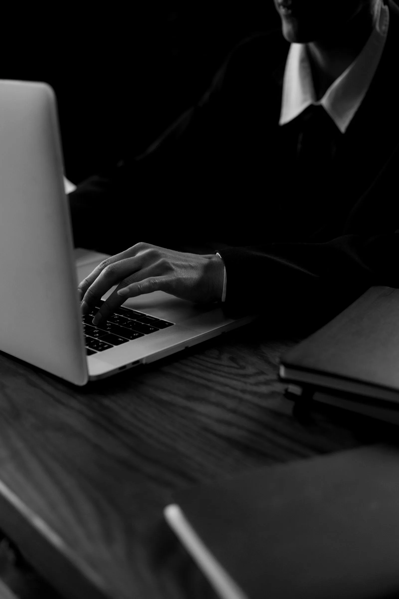 A person reviewing search results on a laptop in a dim room, illustrating an individual checking whether their login credentials were leaked.