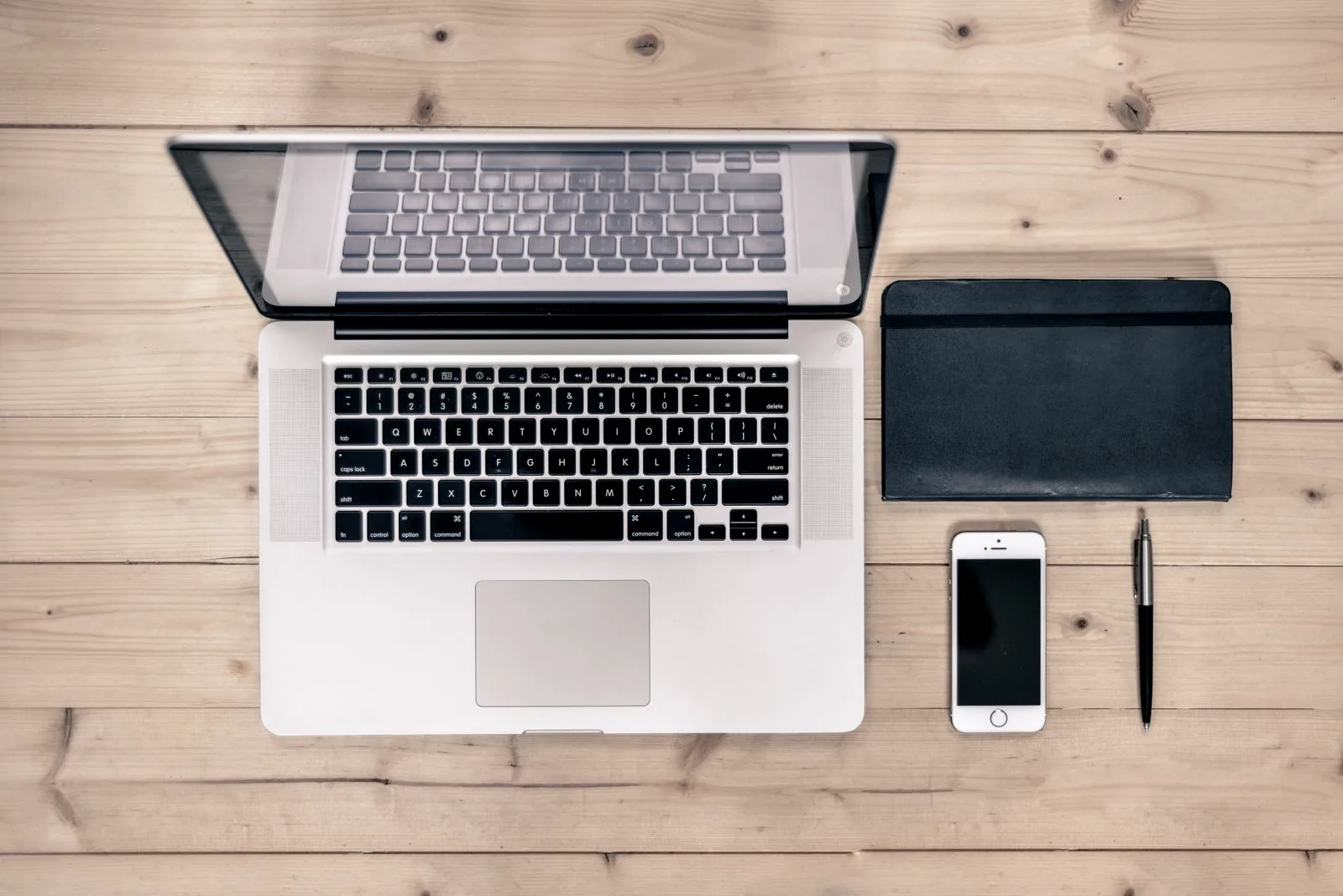 A laptop and phone side by side showing account sign-in screens, the two devices you sign out after a password leak.