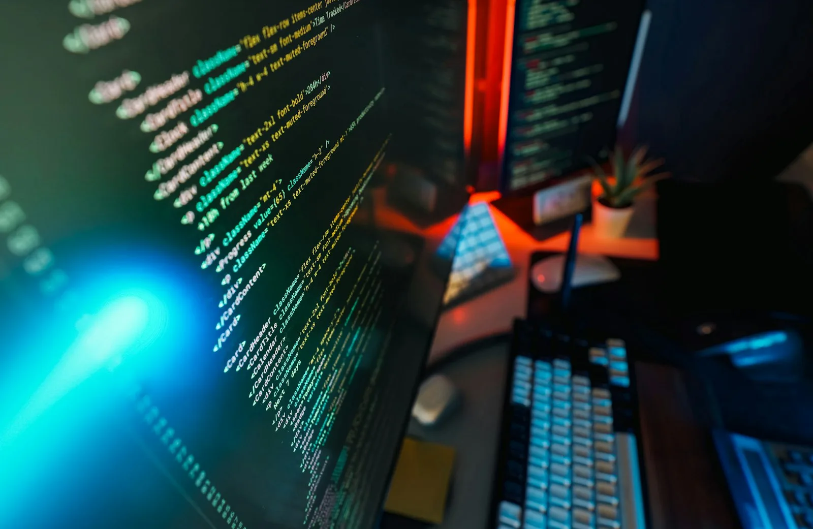 Lines of application code glowing on a monitor in a dark workspace, illustrating how infostealers scrape saved data from a browser.