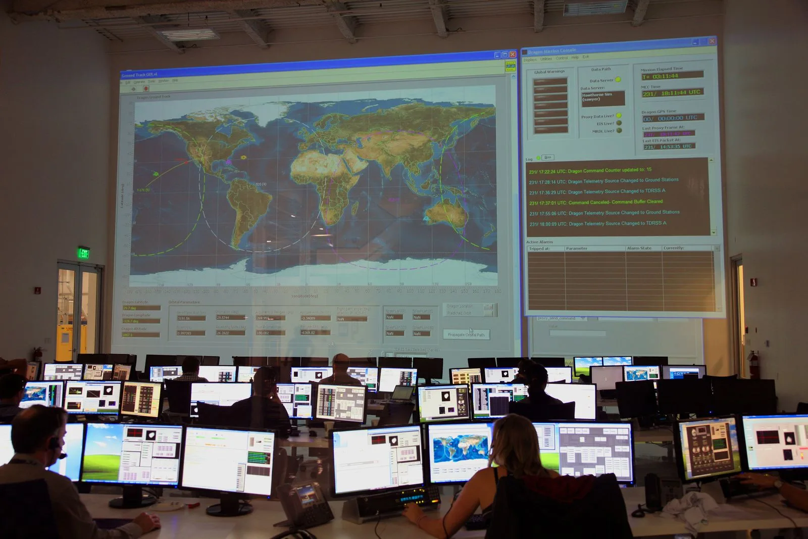 Analysts monitoring rows of screens in a dark operations center, representing outside-in exposure monitoring and threat detection.