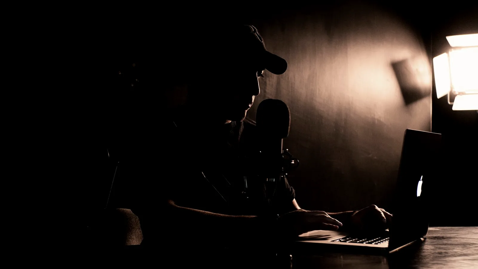A quiet office laptop on a desk, screen on and idle, the ordinary-looking device an infostealer targets without leaving visible symptoms.